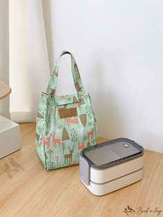 two lunch boxes sitting next to each other on a wooden floor with a white wall in the background