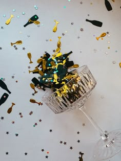 a glass filled with confetti on top of a table