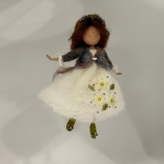 a doll hanging from a string with flowers on it