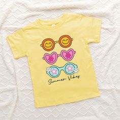 Looking for a cute tee for your kids? We have the perfect Sunnies Summer Vibes graphic tee addition to their closet! Also available in youth tees. Trendy Cotton T-shirt For Playwear, Playful Cartoon Print T-shirt For Playwear, Summer Cotton T-shirt With Character Print, Fun Graphic Print T-shirt For Playwear, Spring Graphic Tee With Character Print, Cute T-shirt For Spring Playwear, Cute Spring Playwear T-shirt, Summer Cartoon Print Playwear T-shirt, Cute Playwear T-shirt For Spring