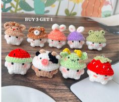 small crocheted animals with hats on top of a wooden table next to a computer mouse