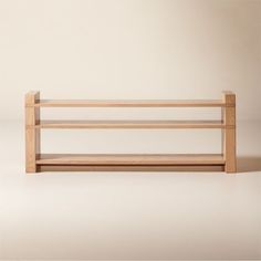 a wooden shelf sitting on top of a white floor in front of a beige wall