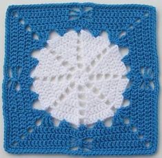 a crocheted square with a white circle in the middle on top of it