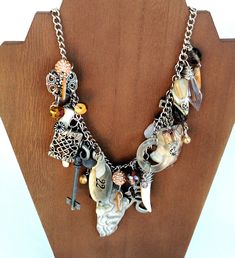 This necklace is made of an assemblage of rescued jewelry, beads and charms both vintage and new. Set on a silver-tone alloy flat chain, there is a beautiful variety of pendants and baubles, including howlite claws, a old key, two slices of polished crazy lace agate, pave rhinestone beads, a frosted class pendant, and much more. This one of kind necklace is wearable art that is interesting, whimsical and eye-catching. Total chain length 26, adjustable Lobster claw closure The photos are consider Unique Metal Necklaces With Dangling Charms, Silver Charm Necklace With Dangling Charms, Unique Silver Charm Necklace With Dangling Charms, Vintage Silver Necklace With Dangling Charms, Artisan Vintage Charm Necklaces, Vintage Style Metal Necklaces With Charms, Artisan Necklaces With Vintage Charm, Silver Bohemian Charm Necklaces With Dangling Charms, Artisan Silver Jewelry With Vintage Charm