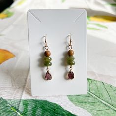 Gold Dangle Earrings Feature Wood Beads, Wine Ruby Garnet Red Crystal Glass Teardrops, Forest Moss Colored Deep Green Jade Beads And French Ball Ear Hooks. Also Available As A Set Approximately 2 Inch Drop Earrings Come With Silicone Stoppers Ships Within 2 Business Days Customization Available Made To Order Made With Love And Care Wine Ruby Garnet Red Crystal Forest Moss Green Jade Wood Bead Casual Earrings / Boho, Western, Dainty, Every Day, Daily Wear, Nature Earrings, Natural Stone, Beads, A Crystal Forest, Forest Moss, Claw Earrings, Bead Dangle Earrings, Earthy Jewelry, Casual Earrings, Garnet Red, Nature Earrings, Gold Dangle Earrings