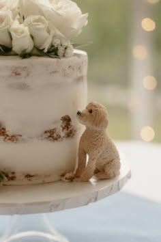 a small dog figurine next to a wedding cake