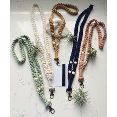 four different colored lanyards with air plants in them on a marble counter top