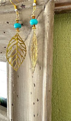 These earrings are a beautiful blend of nature-inspired elegance and boho charm. Featuring a delicate gold-toned leaf pendant paired with a striking turquoise bead, these earrings capture the essence of earthy sophistication. Perfect for adding a touch of nature to any outfit, they are lightweight, versatile, and sure to make a statement. Bohemian Nickel-free Leaf-shaped Earrings, Gold Bohemian Beaded Pierced Earrings, Bohemian Gold Leaf Jewelry, Bohemian Gold Leaf-shaped Jewelry, Bohemian Leaf-shaped Brass Jewelry, Bohemian Brass Leaf Jewelry, Gold Bohemian Leaf-shaped Jewelry, Nature-inspired Turquoise Dangle Earrings, Bohemian Leaf-shaped Pierced Earrings