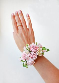 a woman's hand with pink and white flowers on it