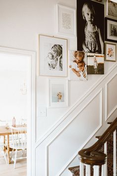 a staircase with pictures on the wall above it