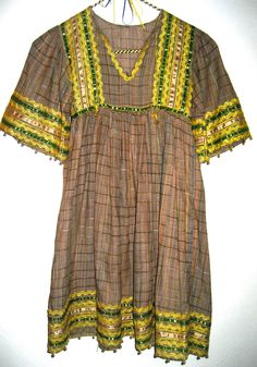 Amazing vintage dress in an ethnic hippie style, has trims and rick rack at neck, bodice, sleeves and hem. Dress is not marked and has no size label, please go by measurements for best results. Perfect for x small adult, condition is good with 2 small areas that can be repaired at top of shoulder. Fabric is a beautiful semi sheer soft cotton with a small raised stitch or weave. Any questions just convo. Thanks!! Across shoulders 11 inches Across bust 14 inches Across waist 14 inches Total length Bohemian V-neck Dress With Crochet Trim, Brown Hippie Boho Dress For Spring, Bohemian Brown V-neck Boho Dress, Boho V-neck Dress With Lace Trim For Festival, V-neck Boho Dress With Lace Trim For Festival, Bohemian Beach Tunic For Fall, Bohemian Brown Boho Dress For Fall, Spring Festival Brown Boho Dress, Brown Flowy Hippie Dress