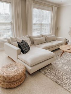 a living room with a large sectional couch and coffee table in it's center