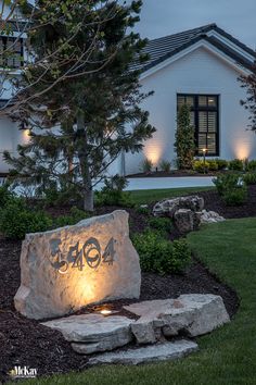 a stone bench sitting in front of a house with lights on it's side