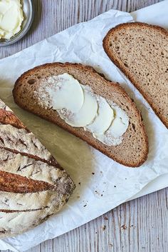 two loaves of bread with butter on the top and another loaf next to it