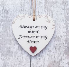 a heart hanging on a wooden wall with the words always on my mind forever in my heart