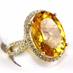 an oval shaped yellow sapphire and diamond ring with two rows of diamonds around the band