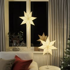 a living room filled with furniture and a christmas tree in front of a large window