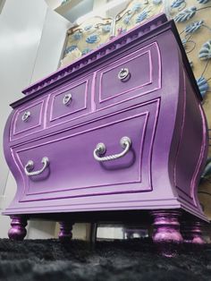 a purple dresser sitting on top of a black rug