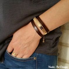 a person wearing a brown bracelet and black shirt