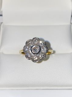 18ct Yellow Gold & Diamond Flower Cluster Ring - 1.00CT  This is a gorgeous ring, A classically designed Diamond Daisy Cluster Ring with nine Brilliant Cut Diamonds set extremely close together to give a fabulous overall appearance when worn. All the Diamonds are very bright and clean and are rim set. The total diamond weight is an impressive 1.00 carat. The ring has very attractive under gallery work which allows lots of light through and the diamonds to sparkle immensely. This ring is set in t Classic White Gold Flower Ring With Rose Cut Diamonds, Classic 14k Gold Round Flower Ring, Classic Round Flower Ring In 14k Gold, Classic 14k Gold Flower Ring With Round Cut, Classic 14k Gold Flower Ring, Classic Jewelry With Brilliant Cut In Flower Shape, Classic Yellow Gold Flower Ring With Prong Setting, Classic Flower Ring With Rose Cut Diamonds, Classic 14k Stamped Yellow Gold Flower Ring