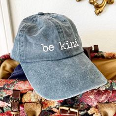 1 Purchased = 1 Book Donated Our Be Kind 'dad' hat spreads a simple yet powerful message of kindness and positivity. This hat serves as a reminder to embrace compassion, empathy, and generosity in our daily lives. Works for all genders. Embroidered on the front with our simple, but impactful, Be Kind mantra. 100% cotton twill Metal snap buckle with an antique brass finish Washed-out vintage effect 6-panel unstructured cap with a low profile Everyday Curved Brim Hat With Letter Print, Adjustable Dad Hat With Letter Print For Everyday, Everyday Adjustable Dad Hat With Letter Print, Everyday Soft-washed Dad Hat With Curved Bill, Everyday Soft-washed Snapback Hat, Everyday Soft-washed Hat With Curved Bill, Everyday Soft-washed Curved Bill Hat, Casual Hats With Letter Print For Gifts, Everyday Dad Hat With Letter Print And Curved Brim