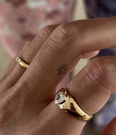 a close up of a person's hand with a diamond ring on their finger