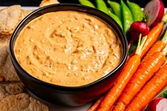 carrots, celery, and crackers are on a plate with dip