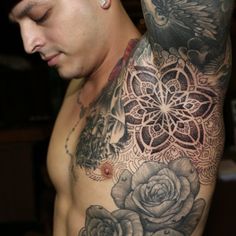 a man with tattoos on his chest and shoulder