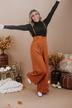 The Setting Trends Suspender Pants in Rust are a trendy and stylish choice for your wardrobe. These suspender pants are perfect for a 30-something mama who loves boutique fashion and wants to make a fashion statement. These pants are a surefire way to set trends and show off your fashion-forward style. Solid Paper Bag High-waist Wide Leg Suspender Pants Wide legs Full length Wide banded high waist Side hidden pockets Made in the USA Inseam: Small 30 in Medium 30.50 in Large 30.75 Rise: Small 15. Orange Trousers Outfit, Colored Pants Outfits, Pant Outfits For Women, Trouser Outfit, Color Pants, Suspender Pants, Pants Outfits, Everyday Chic, Colored Pants