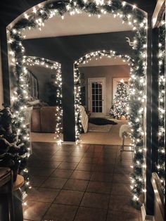 an archway decorated with christmas lights and garlands in a home entry way at night