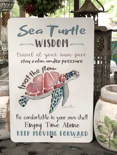 a sign that says sea turtle wisdom next to some potted plants and vases