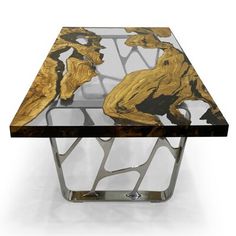 a glass and metal coffee table with gold leaf designs on the top, against a white background