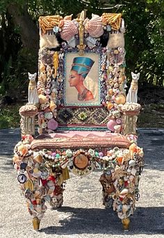 an elaborately decorated chair sitting in the middle of a road with lots of shells on it