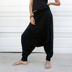 "Black Samurai Style Ninja Pants for Women and Men. This Stretch Cotton Harem Pants Fit Plus Size. -Unisex -Stretch -Flowing relaxed fit -Inner drawstring to secure the waist -2 side pockets Great for Yoga, Dance, Exercises, Meditations, Yoga Practice and beyond... Materials: black color cotton blend (90% cotton 10% lycra). Fabric for this pair were bought in Fashion District, LA and the pant was made in one of the studios in Los Angeles, CA. Measurements: Fits: S, M, M/L -Length: 41\" (~102 cm) Black Hip-length Bottoms For Yoga, Black Cotton Yoga Pants With Elastic Waistband, Black Baggy Hip-length Bottoms, Black Harem Pants With Elastic Waistband And Tapered Leg, Black Stretch Harem Bottoms, Black Cotton Sweatpants For Yoga, Casual Black Harem Yoga Pants, Black Sweatpants For Yoga, Baggy Black Tapered Leg Harem Pants