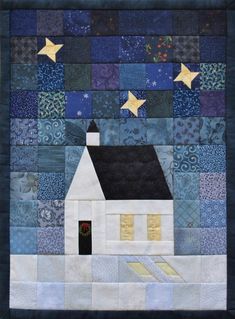 a quilted wall hanging with a house and stars in the night sky on it