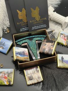 a table topped with pictures and jewelry on top of a black cloth covered tablecloth