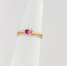 These luxurious cubic zirconia stacking rings are meticulously crafted by hand and feature a striking fuchsia cubic zirconia stone set in a gold-filled bezel. The vibrant dark pink hue of the dark pink cubic zirconia stone complements the bright gold bands, creating a regal and timeless color combination that exudes elegance and beauty. The gold filled arrow accent adds a modern twist on these timeless treasures. Whether for everyday wear or a special occasion, these gold filled stacking rings a Pink Ruby Stackable Jewelry, Pink Ruby Birthstone Ring In 14k Gold, 14k Gold Pink Ruby Ring Birthstone, Gold Ruby Solitaire Birthstone Ring, Gold Ruby Birthstone Ring With Solitaire, Rose Gold Stackable Rings With Pink Sapphire As Gift, Pink 14k Gold Stackable Rings For Anniversary, Rose Gold Pink Sapphire Stackable Rings As Gift, Pink Dainty Birthstone Ring For Anniversary