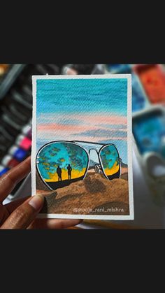 a person holding up a card with the reflection of two people in sunglasses on it