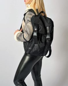 a woman wearing black leather pants and a backpack