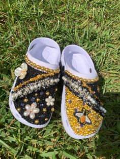 White Shoe Crocs with lots of craftmanship. Black and Gold Embellishments. White Pearls, Rhinestones. Super classy. Adult Size 6 Shoe Crocs, Custom Rhinestone, Clogs And Mules, White Shoe, Sparkle Shoes, Bling Shoes, Gold Embellishment, Clogs Shoes, White Shoes