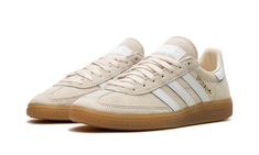 The adidas Handball Spezial “Wonder White” is an easy-to-style colorway of the timeless-looking sneaker.  The upper is complete with a Wonder White suede construction and contrasted with white leather Three Stripes branding on the sides.  Gold “Spezial” and adidas Trefoil logos appear on the lateral side of the mid-panel, while “adidas” branding appears on the white leather heel tab.  A gum sole completes the look.  Release date: December 27, 2023 Adidas Handball Spezial, Adidas Handball, Gold Adidas, Handball Spezial, Holiday Shoes, Adidas Shoes Women, Adidas Spezial, Exclusive Sneakers, Nike Dunk High