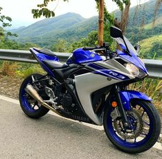 a blue and silver motorcycle parked on the side of a road