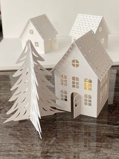 two paper houses with trees in front of them