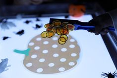 a child is cutting paper with scissors on top of a table full of fake animals