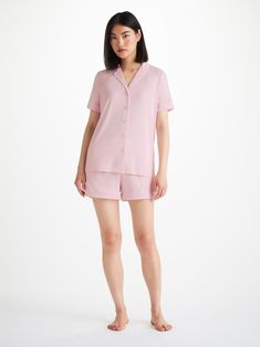 Perfect for lounging in when you get home from work, a good night's sleep and then breakfast round the table in the morning - our ballet pink Lara jersey shortie pyjamas work effortlessly as a versatile modern take on the classic pyjama. Designed for a flattering but comfortable shape, our women's shortie pyjamas will keep you looking great and feeling comfortable throughout the seasons. The short sleeve jacket top features a fully piped finish in a contrasting white piping for a stylish appearance and the shorts have piped cuffs with an elasticated and drawstring waist for practicality. The Lara also has a higher waist for a more natural fit and improved comfort, and the most important addition? Pockets! Lara originated from a desire to make a lighter weight but equally soft version of ou Feminine Pajama Shorts For Lounging, Pink Short Sleepwear With Relaxed Fit, Pink Relaxed Fit Short Sleepwear, Feminine Pajama Shorts For Loungewear, Short Length, Feminine Pajama Shorts For Loungewear, Feminine Loungewear Pajama Shorts, Feminine Pink Sleepwear For Lounging, Feminine Short Sleepwear For Pajama Party, Feminine Short Length Pajama Shorts For Loungewear