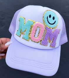 Celebrate mom with this custom trucker hat featuring a cheerful smiley patch! Perfect for everyday wear, this personalized cap adds a fun and trendy touch to any outfit. Whether for a casual outing or a special gift, this unique mom hat is both stylish and practical. Show your love and appreciation with this adorable and custom trucker hat! High quality patches with adjustable SnapBack hat.   💞SHIPPING  We have a 3-5 (business days) processing/shipping turnaround time.  Most orders ship out within 1-2 business days. Trendy Birthday Snapback Hat, Trendy Snapback Hat For Birthday, Adjustable Baseball Cap With Smiley Face, Trendy Birthday Trucker Hat, Spring Letter Print Trucker Hat With Curved Visor, Spring Trucker Hat With Letter Print And Curved Visor, Trendy Trucker Hat For Birthday, Spring Letter Print Curved Visor Trucker Hat, Spring Curved Visor Trucker Hat With Letter Print