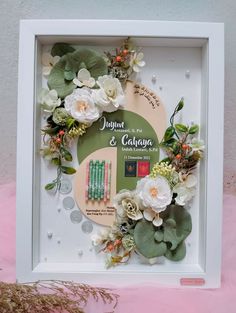 a white frame with flowers and leaves on it