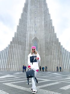 a woman standing in front of a very tall building