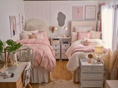 a bedroom with two beds and pink comforters