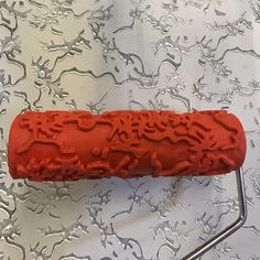 a red object sitting on top of a white table next to a metal rack and wall